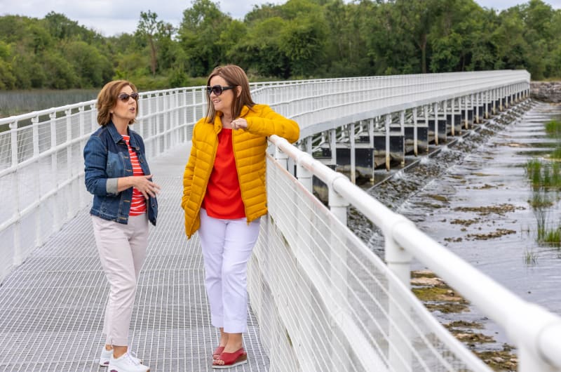 Two women talking on a white bridge