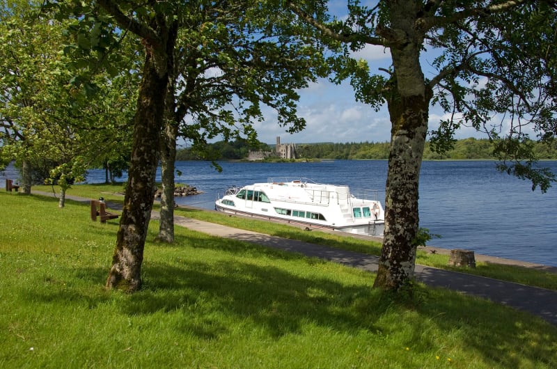 White Cruiser Boat Docked Near Castle Ruins Lake