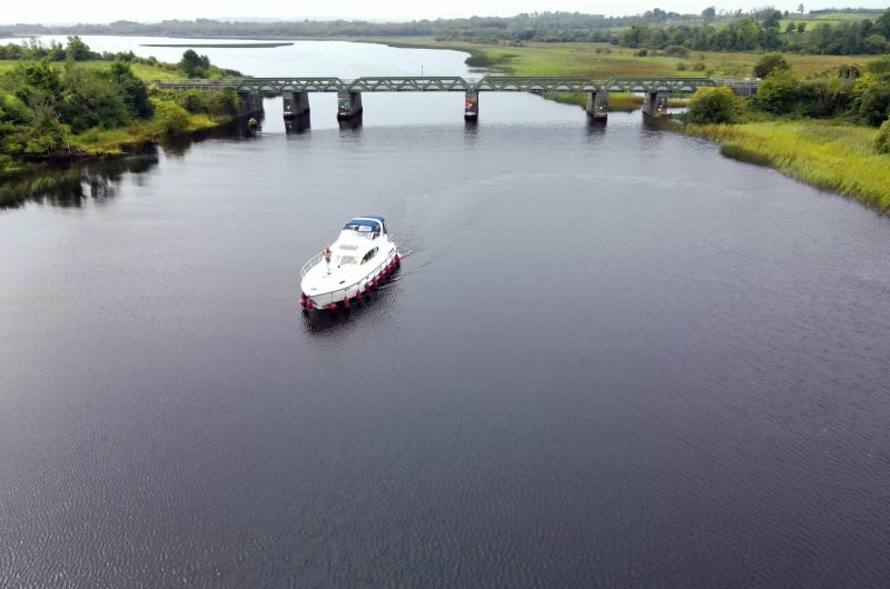 White Cruiser Boat On River With Green Bridge