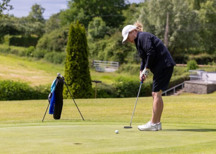 Woman Putting A Golf Ball On A Green