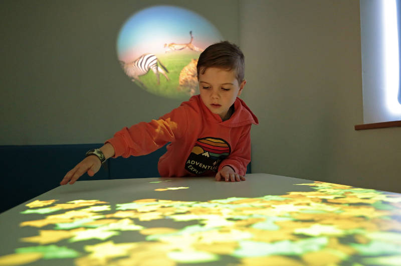 boy looking at projected image on table