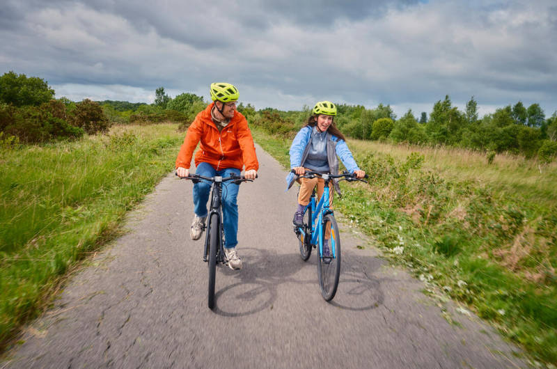 park couple on bikes country road