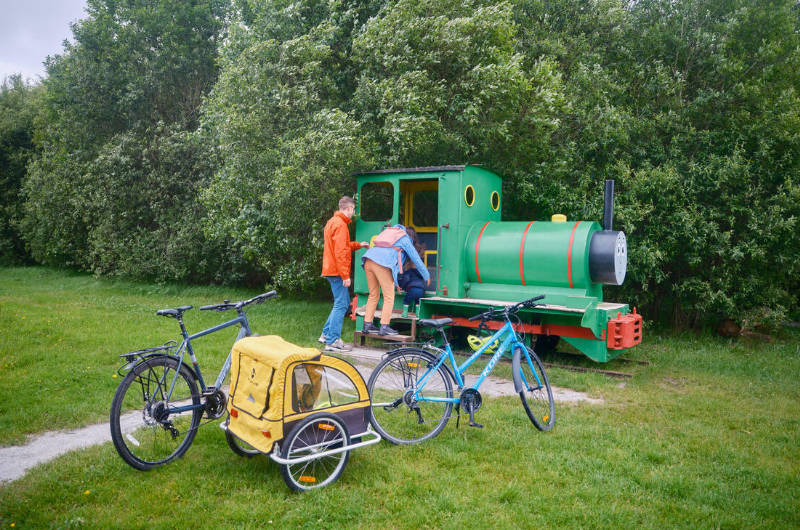 park father and child playing on percy tank engine playground set