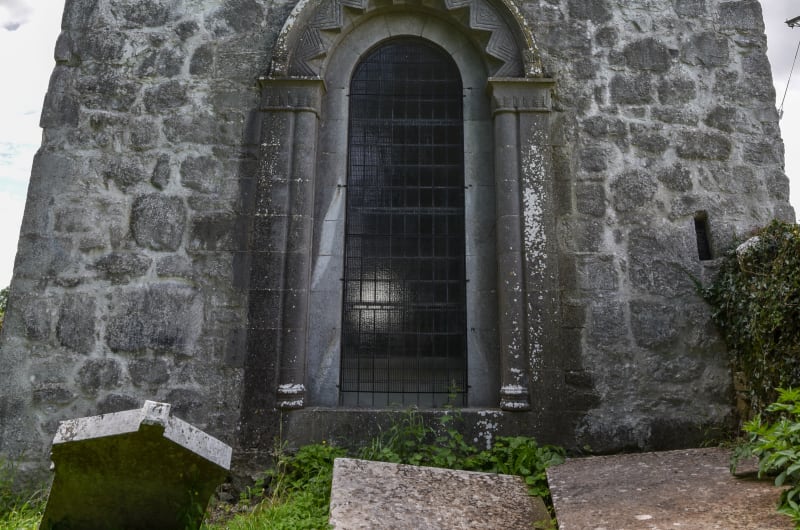 Ancient Stone Chapel With Decorative Arch And Cross