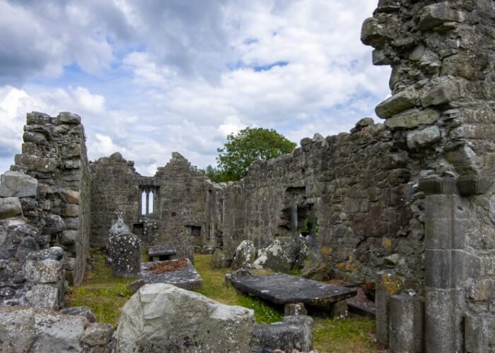 Ancient Stone Ruins With Gravestones Under Cloudy Sky awcxrh
