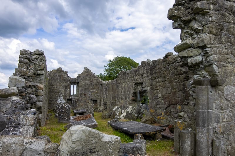 Ancient Stone Ruins With Gravestones Under Cloudy Sky awcxrh