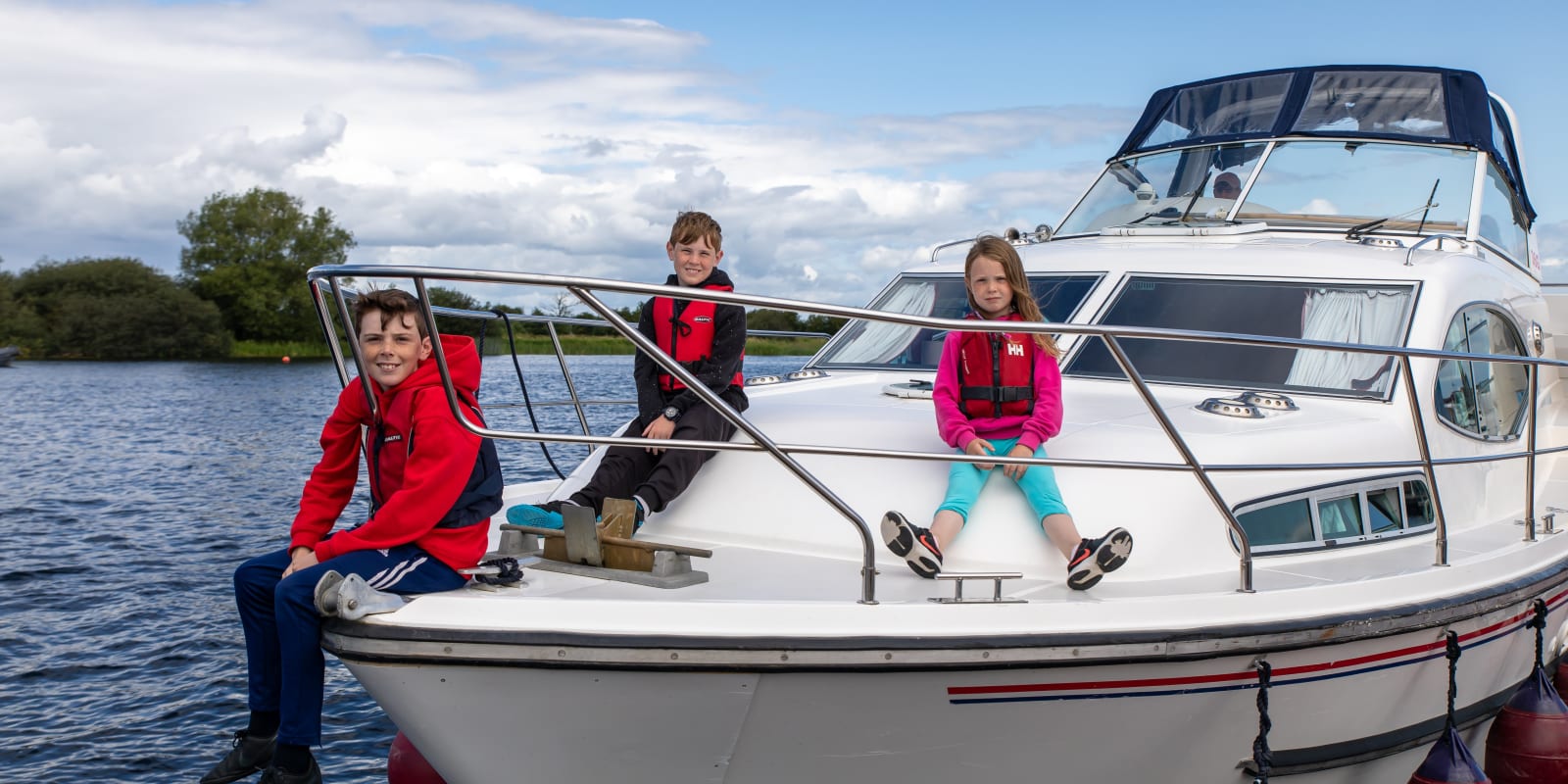 Boating on Grand Canal Header Image Three Children Sitting On White Boat Wearing Lifejackets