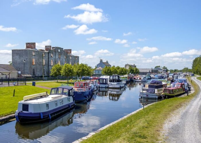 Canal Boats Docked Near A Large Stone Ruin u1e6mz