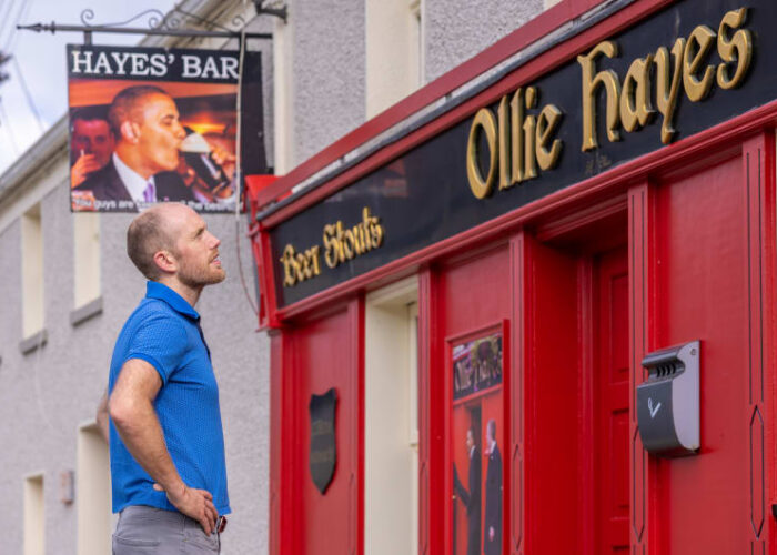 Copy of Man looking at Ollie Hayes pub Obama sign mxfm8j