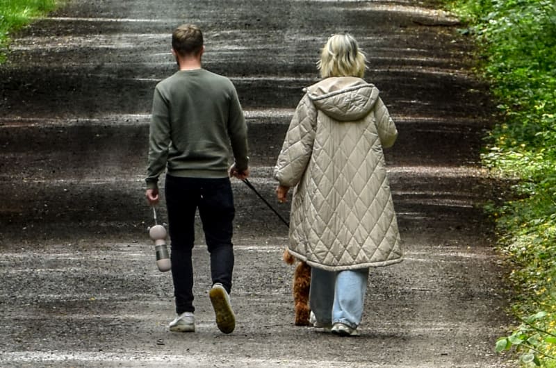Couple Walking Away On Tree Lined Road