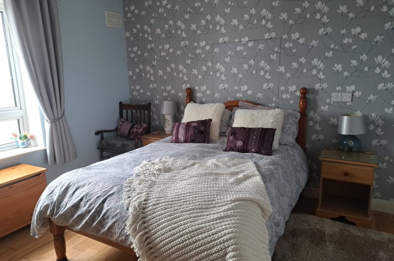 Cozy Bedroom With Floral Wallpaper And Wooden Bed dvsciy