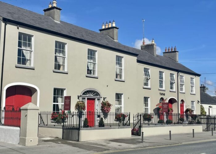Cream townhouses with red doors and flower baskets tjmn0i