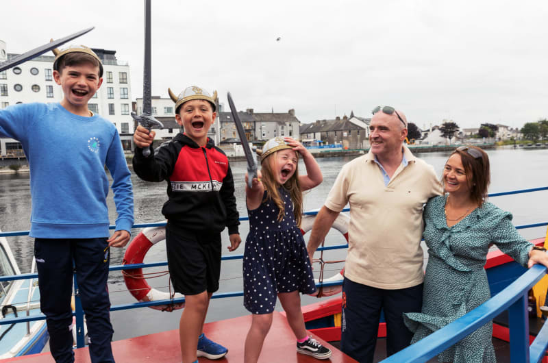Family In Viking Helmets Posing On Boat