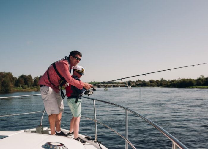 Father and son fishing from a boat. i2pvhw