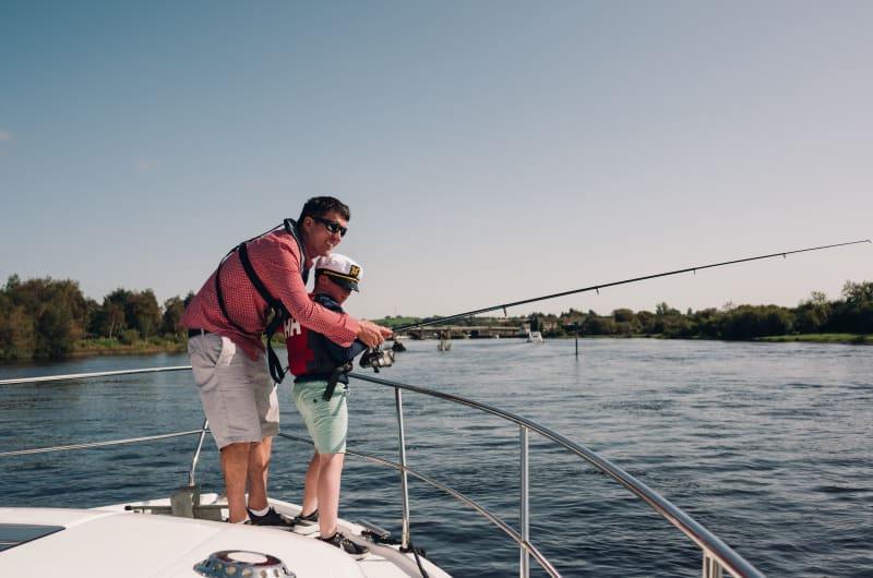 Father and son fishing from a boat