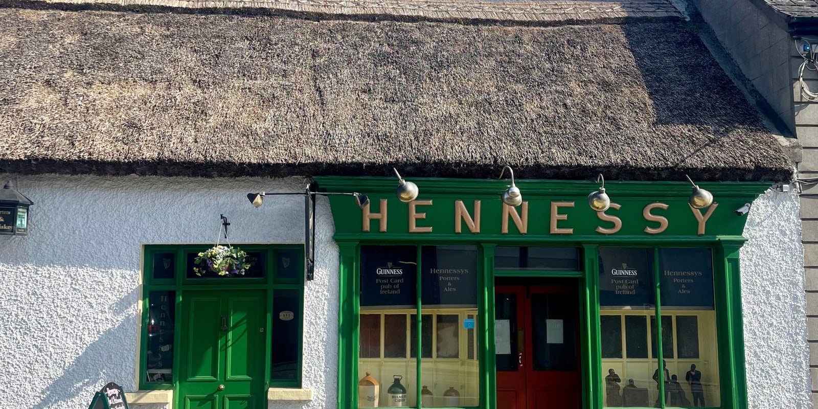 Ferbane Header Image Traditional thatched roof Hennessys Irish pub exterior view