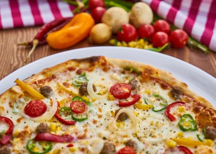 Freshly baked pizza with vegetables on wooden table uiy2wd