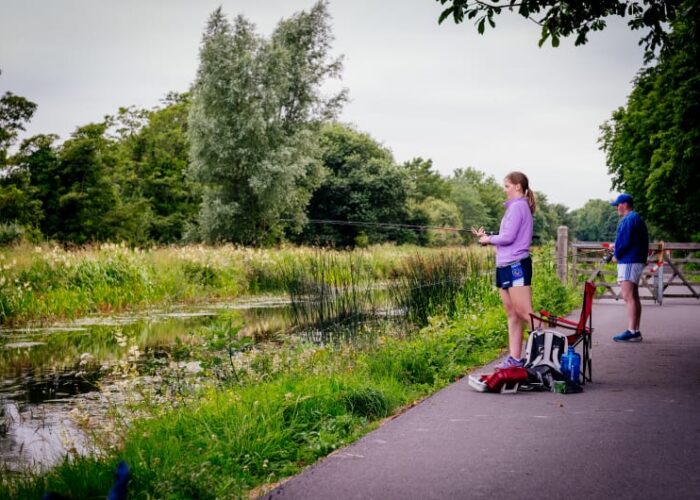 Girl and man fishing by canal greenway path hqggij