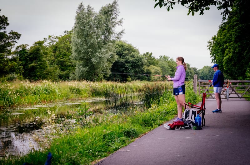 Girl and man fishing by canal greenway path hqggij