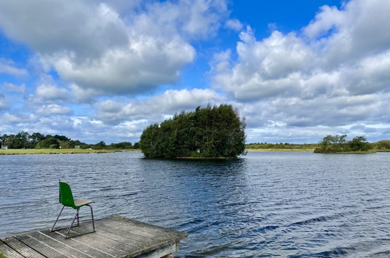 Green Chair On Wooden Dock Overlooking Lake Island nr9zec