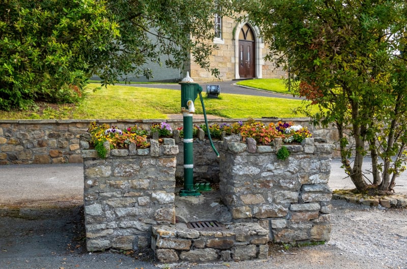 Green Water Pump In Stone Flower Bed wvxvkm