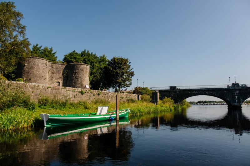 Green boat moored near stone bridge and fortress m7opli