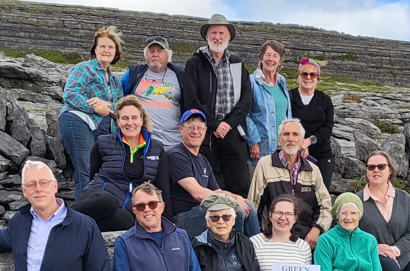 Group posing outdoors with Green Door Tours sign