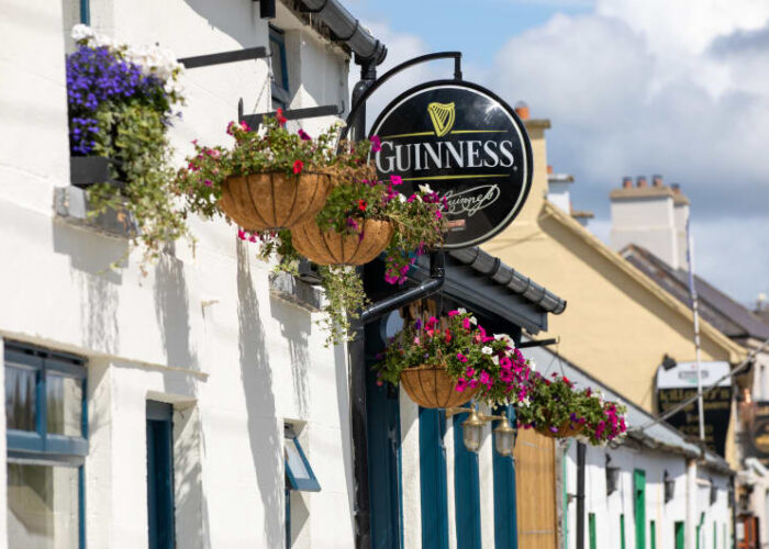 Guinness Sign And Hanging Flowers On White Building ebhyxz