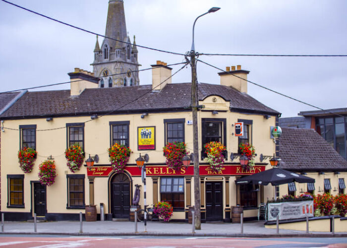 Kellys Bar building with colorful hanging flower baskets ywrqki