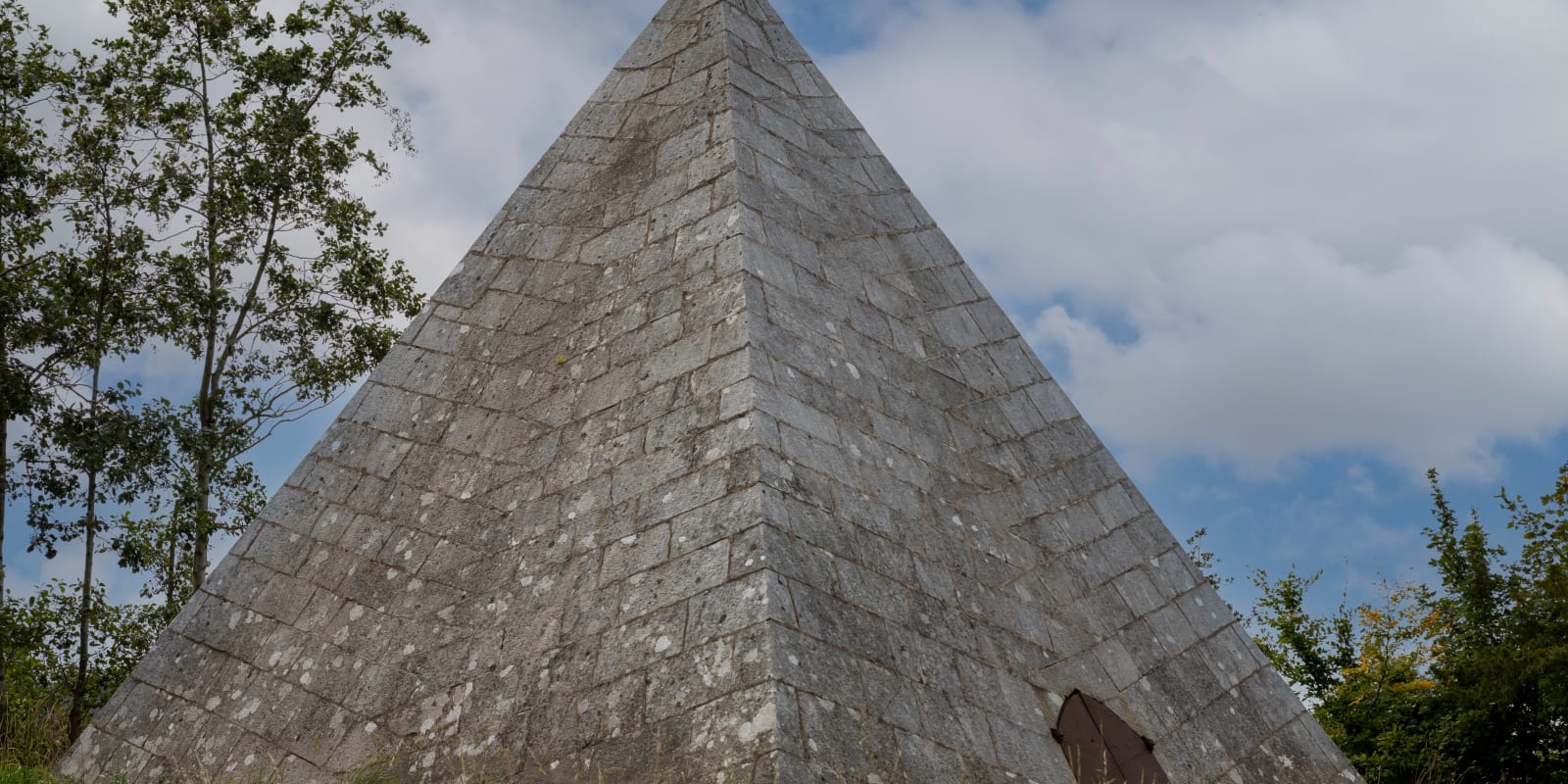 Kinnitty Pyramid Header Image Large stone pyramid with small door in field