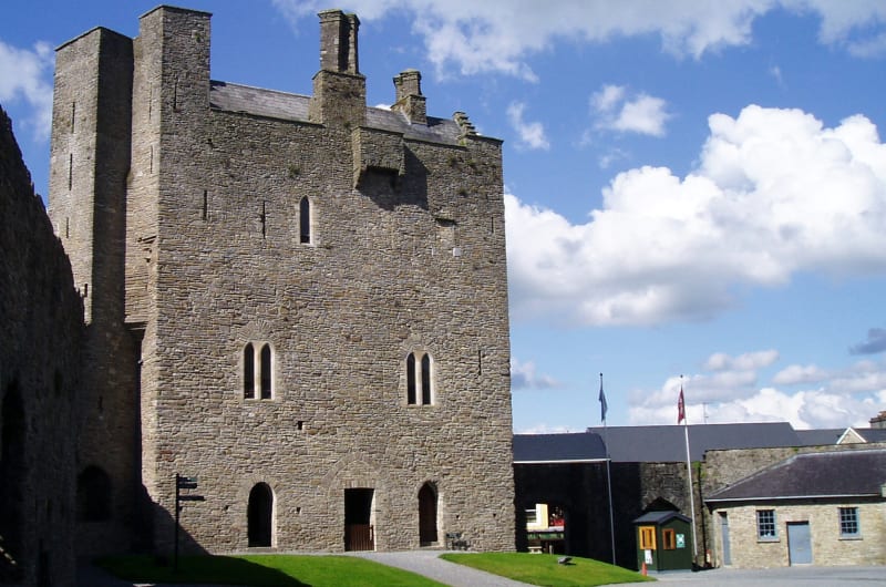 Large stone castle tower overlooking a sunlit courtyard