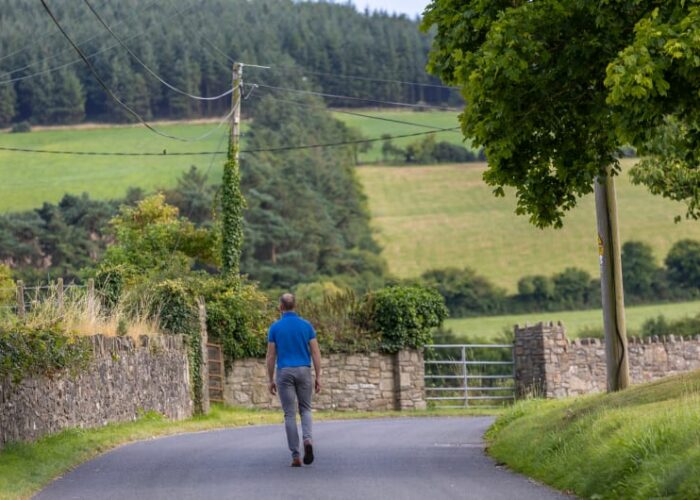 Man Walking Away On Rural Countryside Road uj2d2u