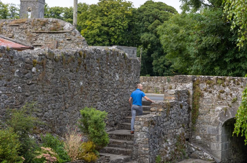 Man Walking Up Stone Steps By Stone Walls qfjyfn