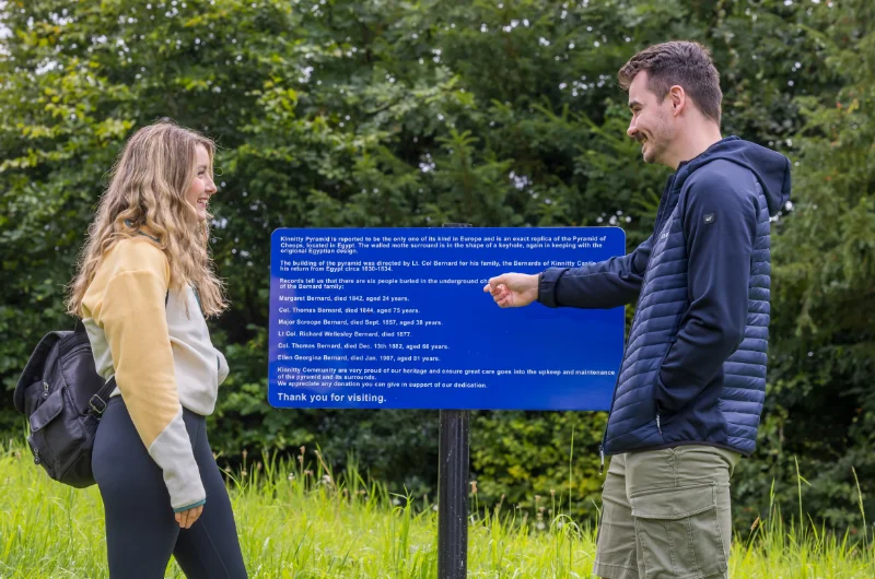 Man and woman reading Kinnitty Pyramid sign fwgc54