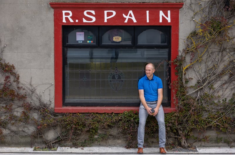 Man sitting in front of R Spain window h4vtz8