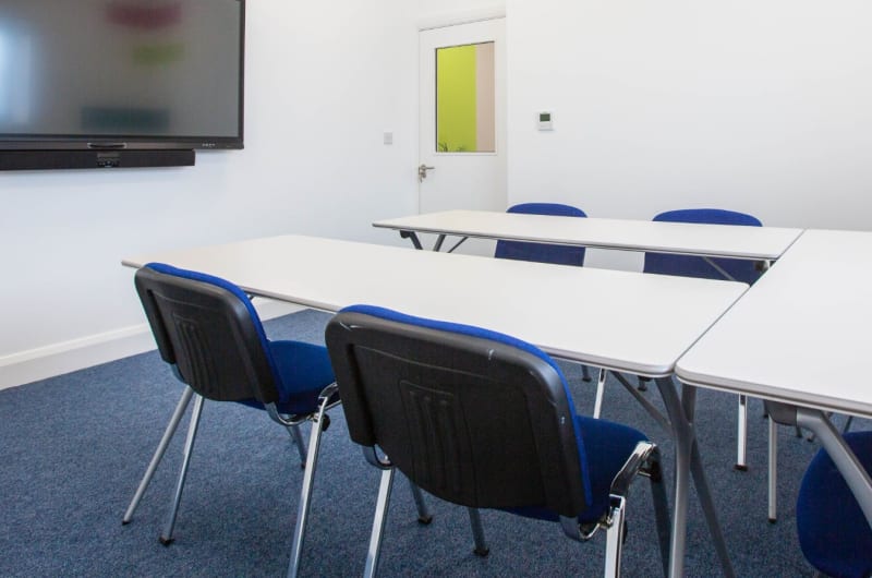 Meeting Room With Large Screen And Blue Chairs