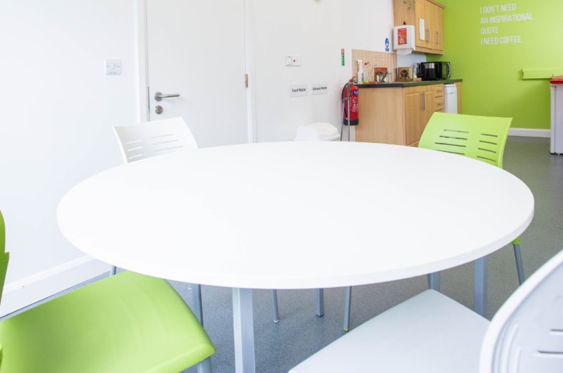 Modern Office Breakroom With Round Table And Kitchenette