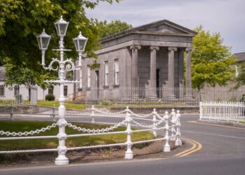 Neoclassical stone building with ornate white lamp post