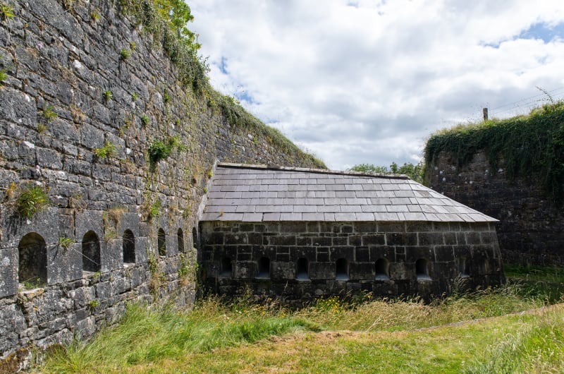Old Stone Building Beside High Stone Wall aux9m7