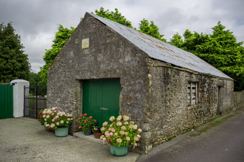 Old Stone Building With Green Doors And Hydrangeas hbzfvc