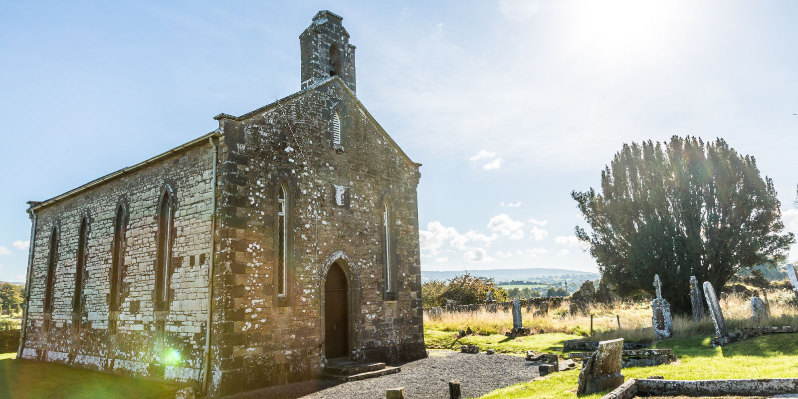 Old Stone Church In A Cemetery With Trees