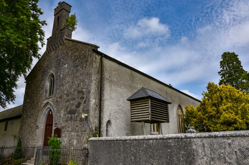 Old Stone Church With Bell Tower And Trees
