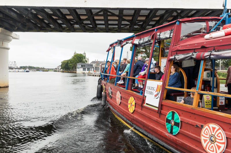 Red Viking Tours boat on river under bridge