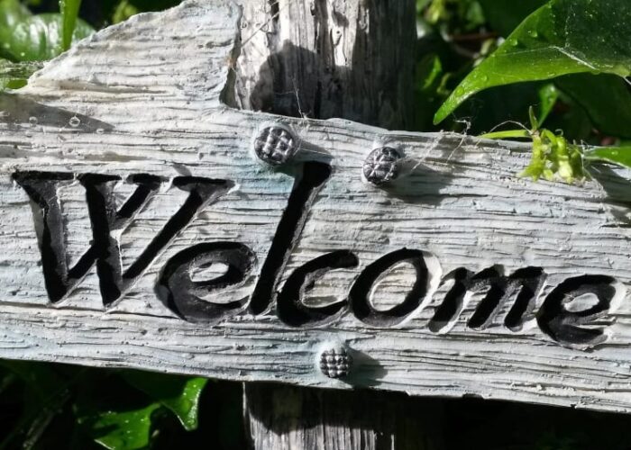 Rustic Welcome Sign Surrounded By Green Leaves lrt2b5