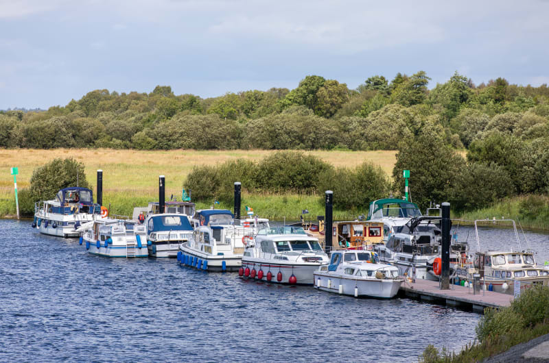 Several motorboats and cruisers docked at a marina wgjrv3