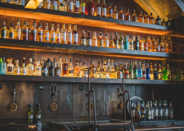 Shelves Of Various Liquor Bottles Behind A Bar j7cbvo