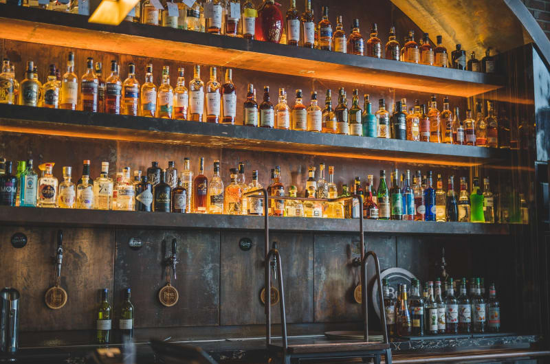 Shelves Of Various Liquor Bottles Behind A Bar j7cbvo