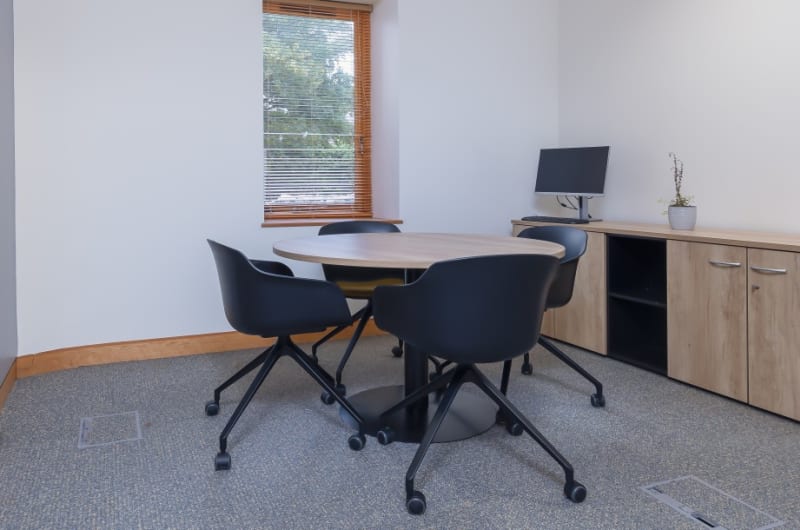 Small meeting room with round table and chairs