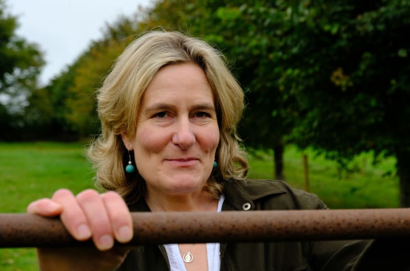 Smiling Woman Holding Onto Rusty Metal Railing Outdoors