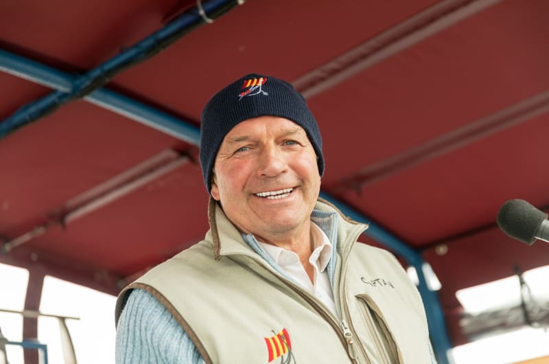 Smiling man wearing captain vest on a boat